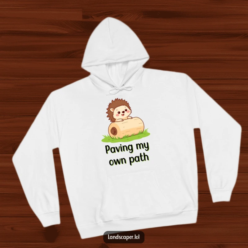 Funny hoodie with a cheerful hedgehog rolling a green lawn roller, offering cozy comfort and hardworking charm.
